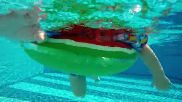 Vista submarina niño activo flotando en la boya de vida en la piscina disfrutando de las vacaciones de verano — Vídeo de stock