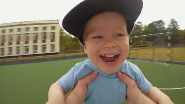 Close-up lachen gezicht van vreugde kleine baby tijdens het roteren in vader handen POV schot — Stockvideo