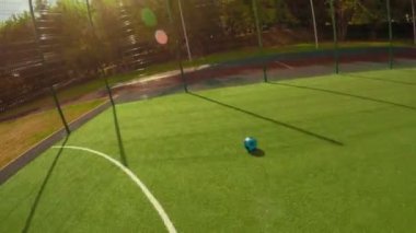 POV aktif bir baba ve yakışıklı bir çocuğu yaz güneşli bir günde spor sahasında futbol oynarken çekti.