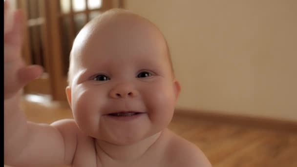 Крупным планом счастливое детское личико улыбается, играя руками, испытывая положительные эмоции, наслаждаясь детством — стоковое видео