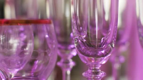 Serveringsbord med många tomma glas bocal redo för fest omgiven av blinkande ljus — Stockvideo