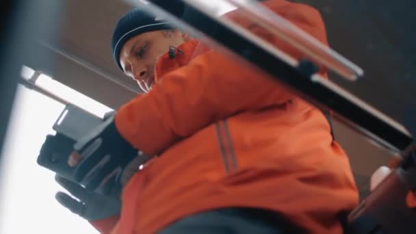 Сосредоточенный мужчина в зимней одежде печатает сообщения в чате используя смартфон в общественном транспорте — стоковое видео