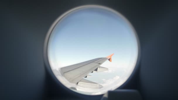 Vue par la fenêtre d'un avion vers l'aile de l'avion, le ciel bleu et les nuages — Video