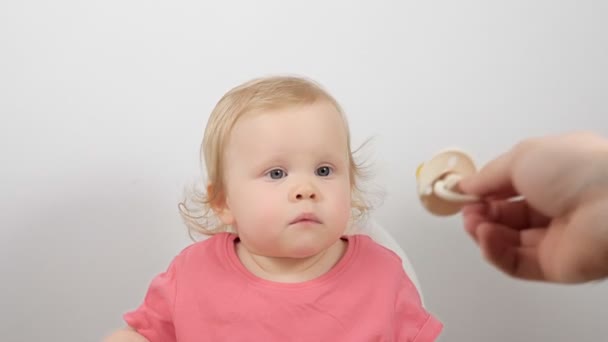 Cuidado padre mano dando chupete a poco lindo bebé niño chica sentado en alimentación silla POV disparo — Vídeo de stock