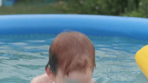 Primer plano niño pellizcando la nariz sumergiéndose en el agua en la piscina inflable infantil — Vídeos de Stock