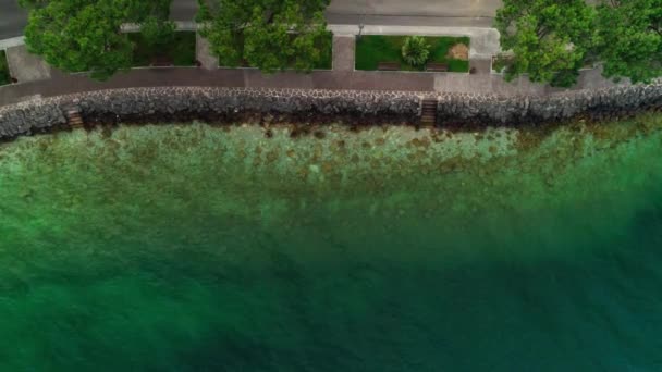 การก่อตั้งทางอากาศภาพบนชายฝั่งชายหาดที่สวยงามล้อมรอบด้วยน้ําทะเลสีเขียวที่ชัดเจนที่น่าตื่นตาตื่นใจพื้นผิวสดใสและหลังคาบ้านเมืองยุโรปเก่าในช่วงฤดูร้อนที่ยอดเยี่ยมแสงแดด — วีดีโอสต็อก