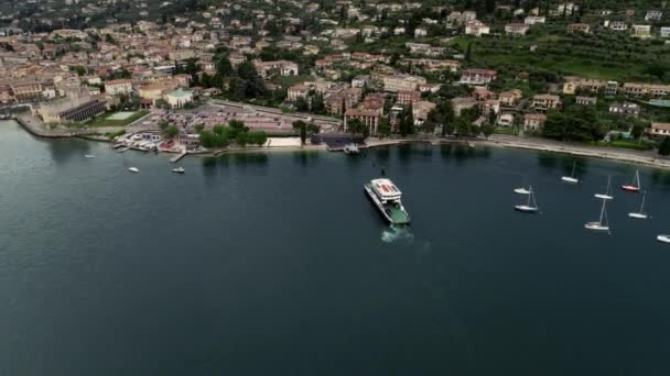 Встановлення повітряного вигляду круїзного човна, що плаває в гавані, наближаючись до набережної туристичного міста вище пострілу — стокове відео