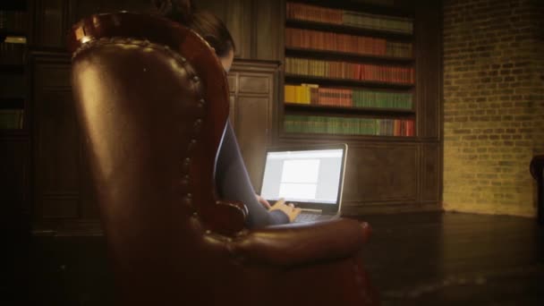 Meisje met laptop in de bibliotheek werken — Stockvideo