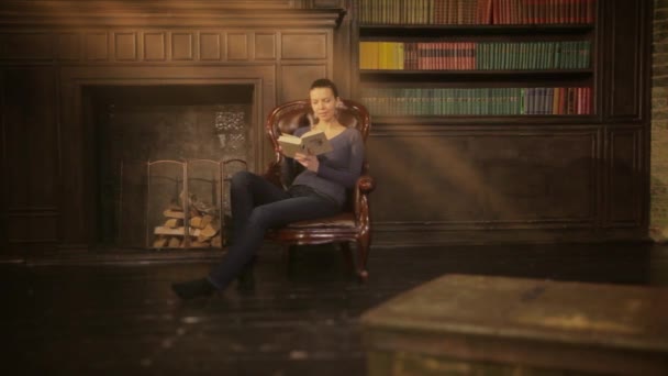 Хорошая девушка читает книгу в библиотеке — стоковое видео