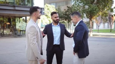 Takım elbiseli üç profesyonel adam, potansiyel iş fırsatları ve değerli ortaklıkları keşfederken güvenlerini ve takım çalışmalarını sergileyerek hareketli bir tartışmaya giriştiler..