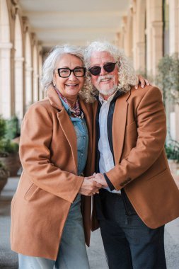 Sevimli bir çift el ele tutuşup, sevgi ve sıcaklık saçarak, keyifli bir gezinti sırasında gülücüklerini paylaşarak, altın yıllarındaki romantizm ve beraberliklerinin özünü yakalıyorlar.