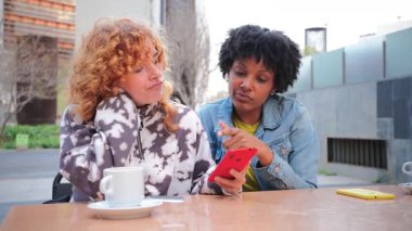 İki neşeli kız, enerji ve mutlulukla dolu heyecanlı bir anda heyecanı paylaşırken akıllı telefonlarıyla kazandıkları zaferi coşkuyla kutluyor..