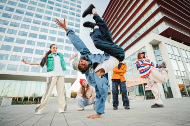Yetenekli break dansçı, heyecan verici bir dans gösterisinde çeşitli hareketleri icra ederken dikkat çekici yetenekler sergiliyor, seyirciyi inanılmaz bir akrobasi ve hareketle büyülüyor.