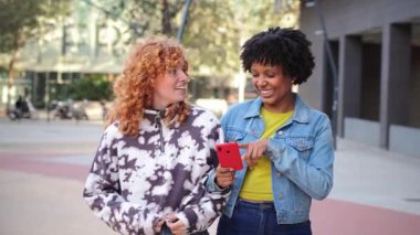 İki neşeli kadın birlikte yürürken neşeli bir sohbete daldılar. Canlı bir açık havada kahkaha ve neşe paylaşıyorlardı. Hatırlanmaya değer bir arkadaşlık ve bağ anı yaratıyorlardı..