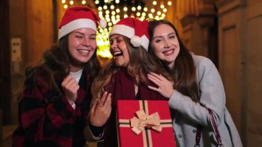 Heyecanlı kadınlar, bayram ruhunu paylaşarak, hediyelerini açarken, Noel Baba şapkalarıyla kahkahalar atarak, tatil sezonunda neşe ve mutlulukla dolu unutulmaz anılar yaratıyorlar.