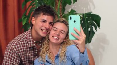 Mutlu bir çift akıllı telefon kullanarak arkadaşlarıyla görüntülü konuşma yapıyor. Onların neşeli ifadeleri aşkın ve birlikteliğin özünü yakalar.