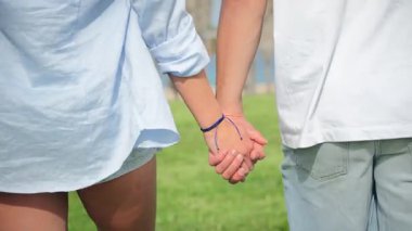 Neşeli bir çift el ele tutuşup, birlikte sakin bir şekilde yürürken, beraberlik ve şefkat dolu huzurlu bir anda aşkı ve bağlantıyı somutlaştırıyor, birlikteliklerini kutluyorlar..