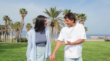 Genç bir çift, el ele tutuşurken, gülümserken, sevgiyi ve bağlantıyı somutlaştırırken, günlük hayatta romantizmi ve arkadaşlığı resmetmek için mükemmel bir şekilde neşeli ve samimi bir gezinti yapar..