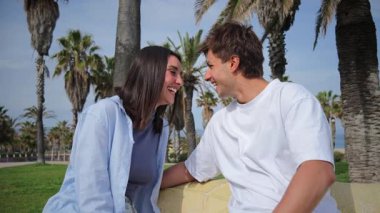 Birbirlerine eşlik eden neşeli bir çift, samimi sohbetler ve kahkahalarla bir arada otururken, sevimli parkta sıcak ve sevgi dolu bir atmosfer yaratıyorlar..