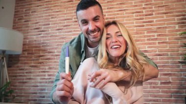Mutlu bir çift hamilelik testi yaparken heyecanlarını paylaşıyor. Yeni mutluluğun heyecan verici anlarını kucaklıyor ve hayatlarındaki aile büyümesini öngörüyorlar..