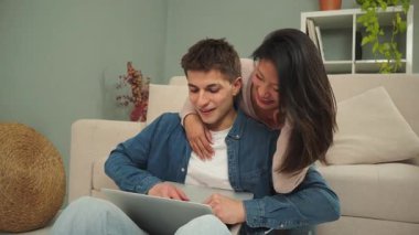 Mutlu bir çift, dizüstü bilgisayarlarında bilgi ararken, evde geçirdikleri zaman boyunca şefkat ve bağlantı göstererek, sıcak bir atmosfer yaratarak, keyifli bir an yaşadılar..