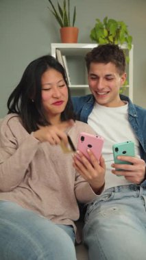 Neşeli çift, akıllı telefonlarıyla çeşitli uygulamaları keşfederken, rahat bir ortamda cep telefonlarını kullanırken, deneyimleri ve kahkahaları paylaşırken, eğlenceli bir aktiviteye girişiyor..