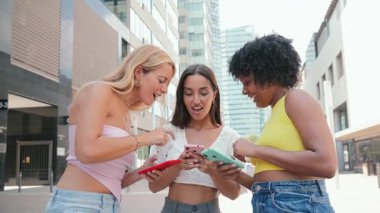 Akıllı telefonlarıyla neşe içinde eğlenen bir grup arkadaş, neşeli bir anda kahkaha ve heyecan paylaşıyorlar. Bağlantı ve teknolojiyle dolu, dostluk ve paylaşılan deneyimler sergiliyorlar..