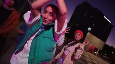 A group of friends joyfully engaging in dance, showcasing their excitement and camaraderie in a lively setting during the vibrant dusk hours, creating a captivating and memorable moment together.