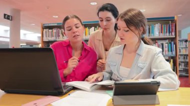 Üç kendini işine adamış öğrenci notları incelerken ve dizüstü bilgisayarlar ve kitaplar etrafında fikirleri tartışırken birlikte çalışırlar. Takım çalışmaları akademik başarının ve öğrenmenin önemini vurguluyor.