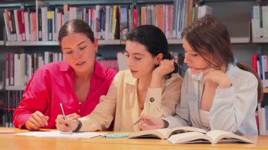 İşbirlikçi çalışmalara dalmış, ders kitaplarını analiz ediyor ve anahtar akademik kavramları konsantrasyon ve takım çalışması ile tartışıyor, konu hakkındaki anlayışlarını geliştiriyorlar.