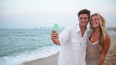 Mutlu bir çift kumsalda selfie çekerken mutlu olurlar. Zamanlarının tadını çıkarırlar. Sıcak güneşin ve okyanusun yumuşak dalgalarının altında gülücükler ve kahkahalarla dolu kalıcı anılar yaratırlar..