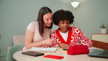 İki öğrenci fikirlerini paylaşırken, görevler üzerinde işbirliği yaparken ve üretken çalışma oturumlarına katılırken, akademik çabalarla arkadaşlığı ve takım çalışmasını teşvik ederken ödevlerine odaklandı..