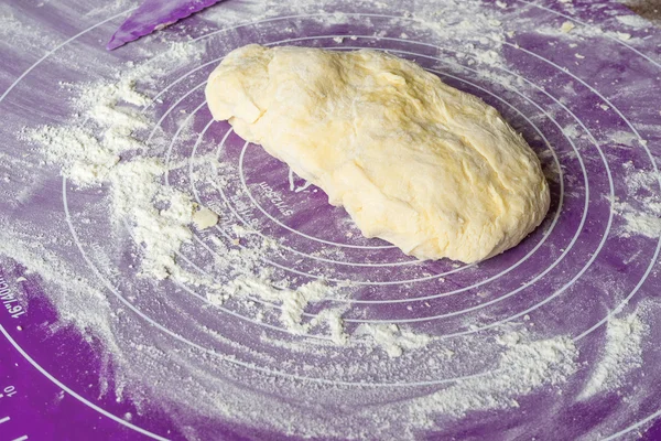 Massa de pizza em um tapete de silicone com farinha — Fotografia de Stock