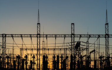 Yüksek gerilim güç Kulesi ve siluet güç hatları günbatımı.