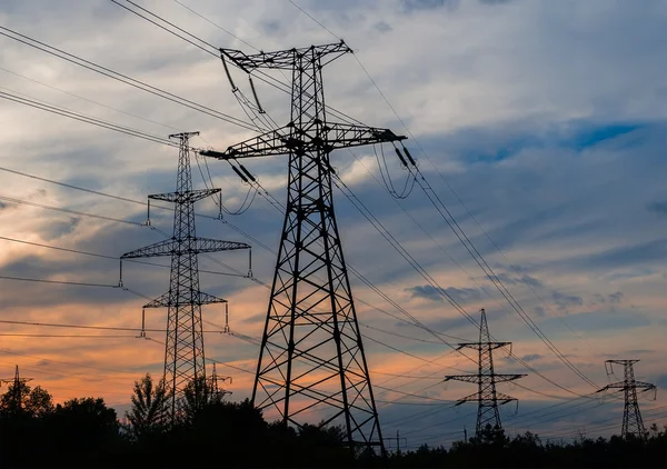 Strommasten und Leitungen bei Sonnenuntergang. — Stockfoto