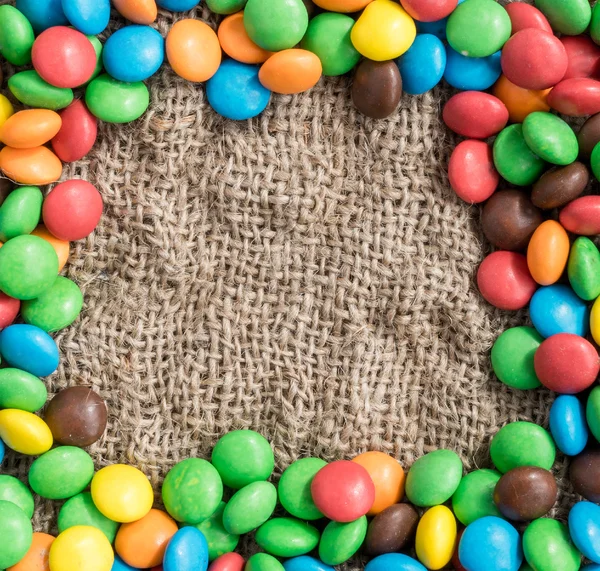 Espaço vazio para texto em uma moldura de doces coloridos. fundo têxtil — Fotografia de Stock