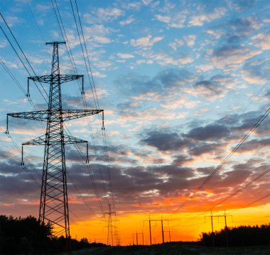 Gün batımı arka planda siluetleri yüksek gerilim elektrik pilon