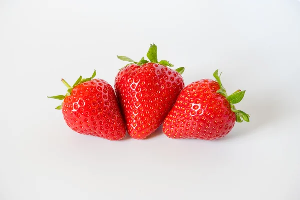 Trois savoureuses fraises mûres et rouges aux feuilles — Photo