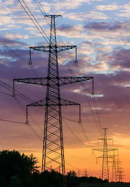 Av metall med hög spänning kraftledning under solnedgången eller sunrise — Stockfoto