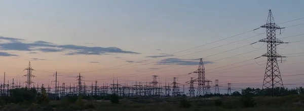 Postes de eletricidade silhueta contra o pôr do sol — Fotografia de Stock