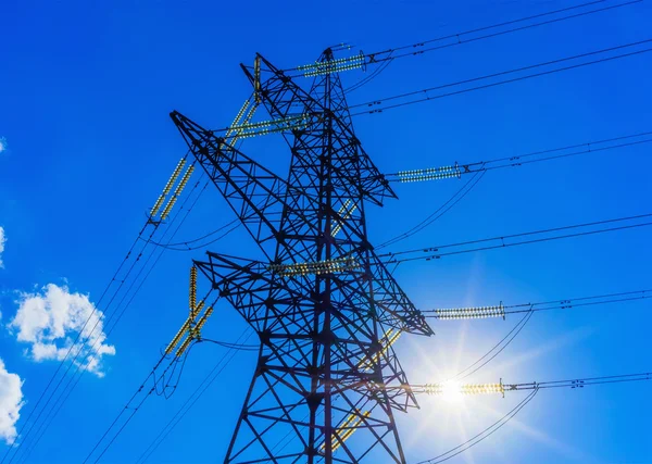 High voltage post. High-voltage tower sky background sun. Stock Photo