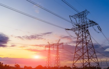 Elektrik direkleri ve ufukta hatları güzel gökyüzü ve gün batımı.