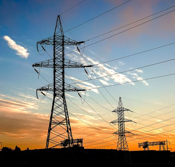 Silueta de líneas eléctricas en la fábrica y fondo del atardecer —  Fotos de Stock