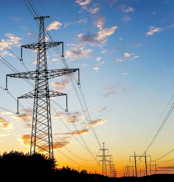 Eletricidade Pylon - torre de transmissão de linha de alimentação aérea padrão ao pôr do sol . — Fotografia de Stock