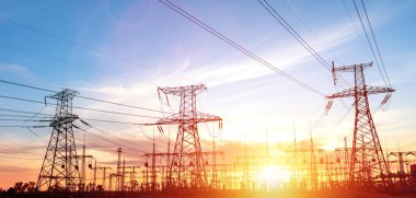 Gün batımında ya da gün doğumunda yüksek voltajlı elektrik hatları. Yüksek voltajlı elektrik iletim kulesi.