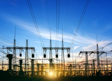 Gün batımında ya da gün doğumunda yüksek voltajlı elektrik hatları. Yüksek voltajlı elektrik iletim kulesi.