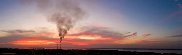 Panorama of an industrial landscape. Thermal power plant on a background of red sunset, aerial view.