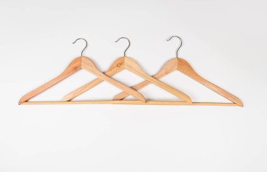 Hafif arka planda ahşaptan yapılmış elbise askıları. Çevre dostu malzemeden yapılmış askılar.