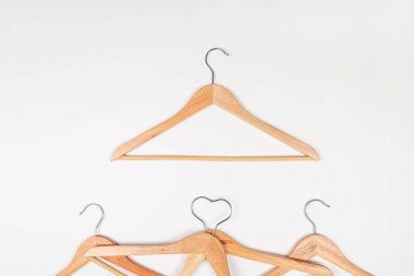 Hafif arka planda ahşaptan yapılmış elbise askıları. Çevre dostu malzemeden yapılmış askılar.