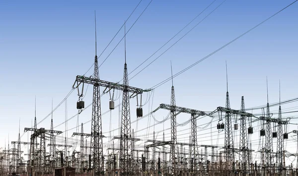 power line pylons and transformers in the daytime. distribution, transmission and consumption of electricity.